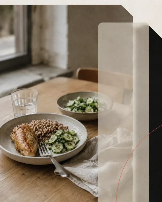 Обычный обед на столе у окна: крупа, запечённая курица, салат из огурцов, стакан воды